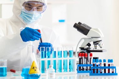 Bilim adamları kan örneği test tüpü tutuyor ve Coronavirus covid-19 salgınına karşı aşı geliştirmek için araştırmasını inceliyorlar. Tıp bilimi ve teknoloji konsepti.