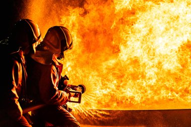 İtfaiyeciler, yangını kontrol etmek için yangını söndürmek için yangın söndürücü kullanırlar, yayılmak için değil. İtfaiyeci ve endüstriyel güvenlik kavramı.