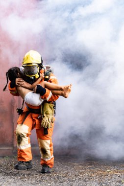 İtfaiyeci kız çocuğu yanan binadan kurtardı. Kızı kucağına aldı ve binadan çıkan dumanların arasından kaçtı. İtfaiyecilerin kazadan kurtarılması ve kamu hizmeti kavramı.