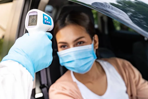 Ppeのある医療スタッフ病院内のドライブスルーステーションでのコロナウイルスCovid 19テストの前に アジアの女性に熱のための温度を取ります サービスと医療の概念を通した新しい通常の医療ドライブ — ストック写真