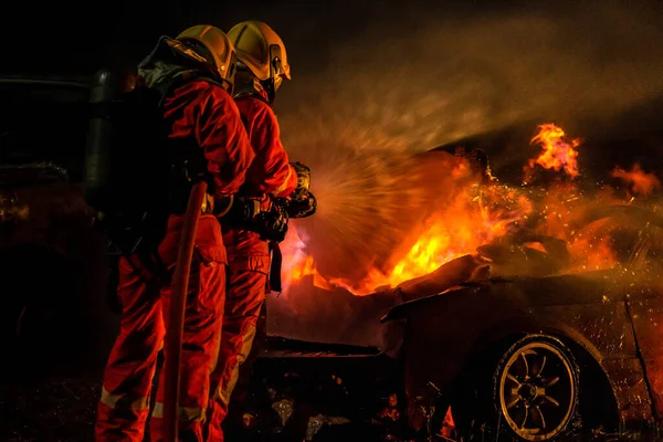 消防士は高速道路の交通事故による火災と戦うためにツイル水霧消火器を使用しています 消防防災 公共サービスの考え方 — ストック写真