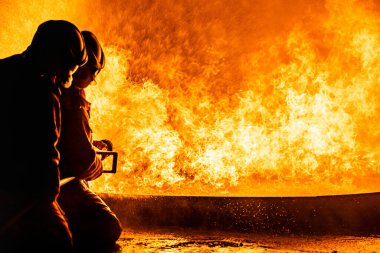 İtfaiyeciler, yangını kontrol etmek için yangını söndürmek için yangın söndürücü kullanırlar, yayılmak için değil. İtfaiyeci ve endüstriyel güvenlik kavramı.