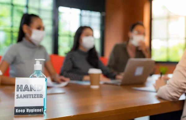アジアチームのビジネス関係者が働いているとブレインストーミングの背景と会議室でハンドサニタイザーアルコールゲルの署名 彼らは新しい通常のオフィスで顔マスクを着用し Covid 19ウイルスが拡散するのを防ぎます — ストック写真