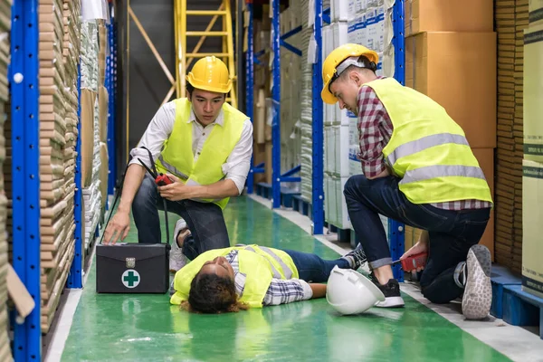 Lavoratore Del Magazzino Primo Soccorso Suo Collega Sdraiato Sul Pavimento — Foto Stock