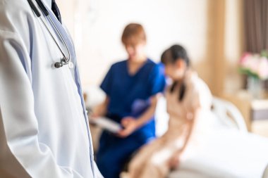 Steteskoplu bir doktor koğuşta hasta ziyaretine geliyor. Hasta odasında küçük bir kızla ilgilenen hemşirenin bulanık geçmişi var. Tıbbi sağlık konsepti.
