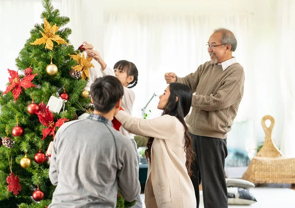 クリスマスツリーを飾る多世代のアジアの家族 お母さんお父さんの娘の女の子と祖父は メリークリスマスとハッピーホリデーの季節の挨拶のためのクリスマスツリーの準備を飾る — ストック写真