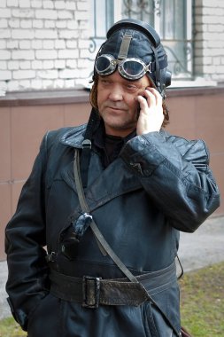 bir pilot, bir cep telefonundan konuşuyor 40s havacı eski bir deri üniformalı erkeklere. Ölümsüz alay alay katılımcı onuruna Büyük Vatanseverlik Savaşı gazileri