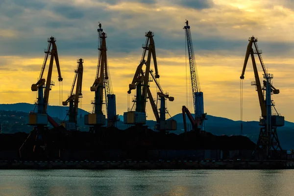 Siluet vinç Port şafakta yükleme. Gökyüzü bulutlu sabahın erken saatlerinde