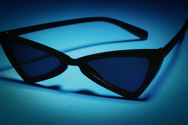 Occhiali da sole neri su sfondo blu — Foto Stock