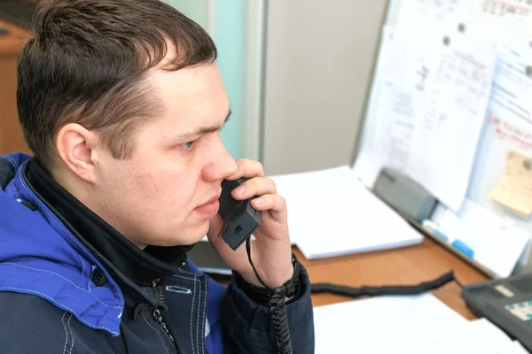 The dispatcher answers the phone. Young man in the workplace.