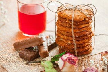 Yulaf ezmeli kurabiye kırmızı çay ve çikolata ahşap arka plan üzerinde. Natürmort rustik tarzda.