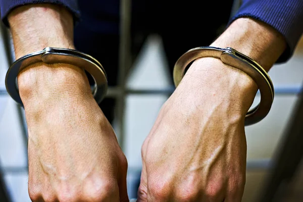 Male hands in metal handcuffs closeup. A prisoner in jail. the concept of punishment for a crime — Stock Photo, Image