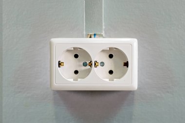 Çift Kişilik beyaz soket gri bir duvar. Yakın çekim. Önden görünüm.