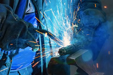 Kaynakçı eldiven fabrikası metal bir parça kaynak. Parlama sihirbaz duman ve kıvılcım