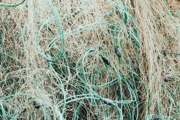 Tangled fishing nets fill the screen in close-up.