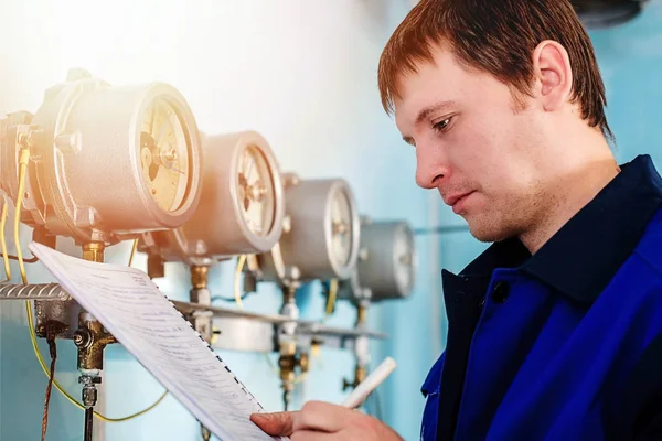 Ingegnere, il lavoratore registra le letture di sensori e manometri. Controllo dell'approvvigionamento idrico e del sistema di riscaldamento — Foto Stock