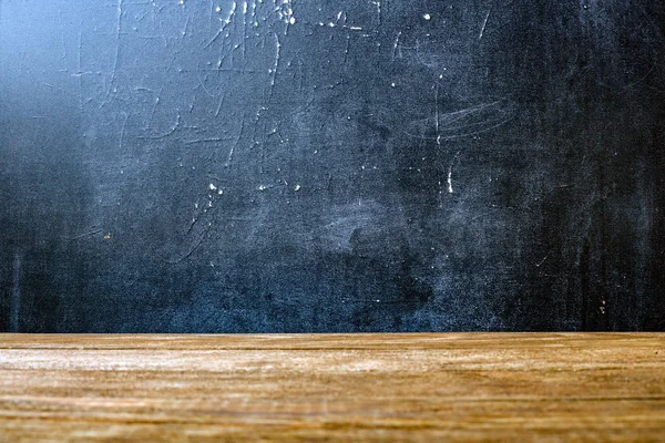 Die Oberfläche der groben hölzernen Tischplatte und der mit Kreide befleckten Schultafel. Stockbild