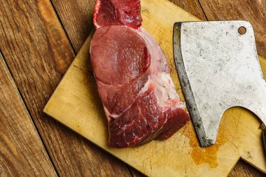 Kesim et için bir balta ve taze sulu biftek kesme tahtası yalan. Et yemekleri yemek pişirmek için arka plan