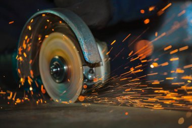 Yakın çekim yuvarlak yüzey açısı değirmeni dönme işlemi sırasında. Parlak metal kesme kıvılcım
