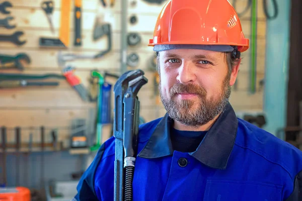 Encanador de trabalho barbudo com chave grande na mão . — Fotografia de Stock