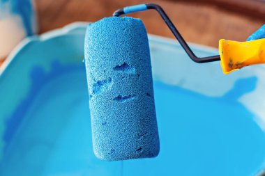 Mavi boya yakın çekim duvarları boyama ksilindir. Binaların onarımı. Bir ressamın hizmetleri