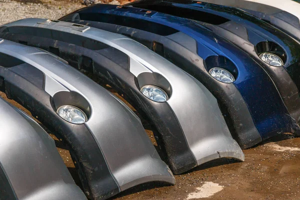 Muitos pára-choques dianteiros do carro são dobrados em uma fileira. A analisar. Loja de reparação de automóveis — Fotografia de Stock