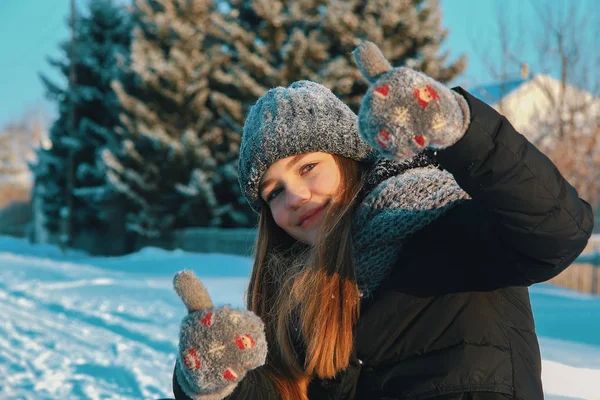 Beautiful white girl outdoors on a winter day shows like. The concept of vacation in the countryside in the winter or at Christmas. — Stock Photo, Image