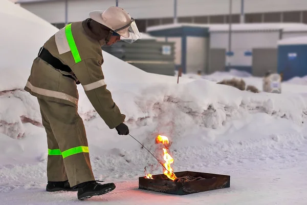 Fireman makes a fire outdoors. Training the pressure of the open fire in the winter.