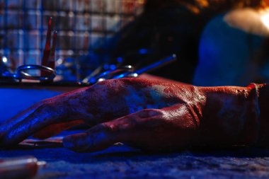 Kanda kopmuş bir el ve kafaların bir kısmı masanın üzerinde yatıyor. Ürpertici ve kasvetli bir atmosferile sahnelenen fotoğraf. Kurban cinayeti ve parçalanması kavramı.