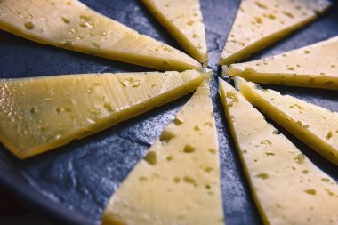 Siyah bir arka plan üzerinde sarı peynir parçaları bir sürü.