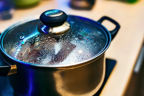 Fém serpenyő a ködös fedéllel. Vízcseppek az edényeket főzés közben az elektromos tűzhely. Közelről. A nézet felülről. — Stock Fotó