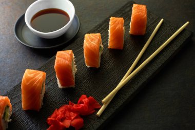 Suşi ruloları. Karanlık stil. Bir Japon restoranında yemek servisi. Kopyalamak için en üstteki görünüm. Pazarlamada minimalizm