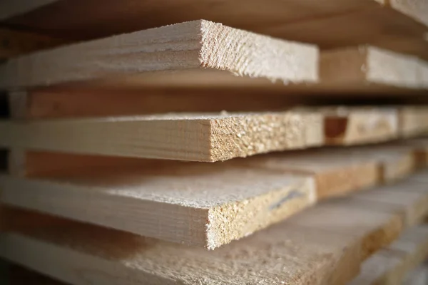 Стек натуральных грубых деревянных досок крупным планом. Хранение древесины в столярной мастерской или на лесопилке — стоковое фото