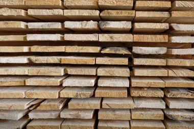 Doğal sert tahta yığını, yakın plan. Marangoz atölyesinde ya da kereste fabrikasında odun deposu.