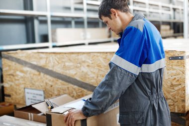 Depo işçisi malların envanterini çıkarıyor.