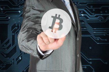 Dijital arka plan üzerinde Bitcoin simgesi olan sanal düğmeye işadamı 