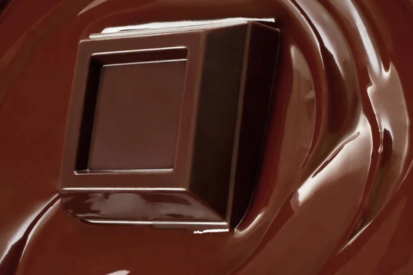 Melted chocolate dripping with chocolate bar close-up