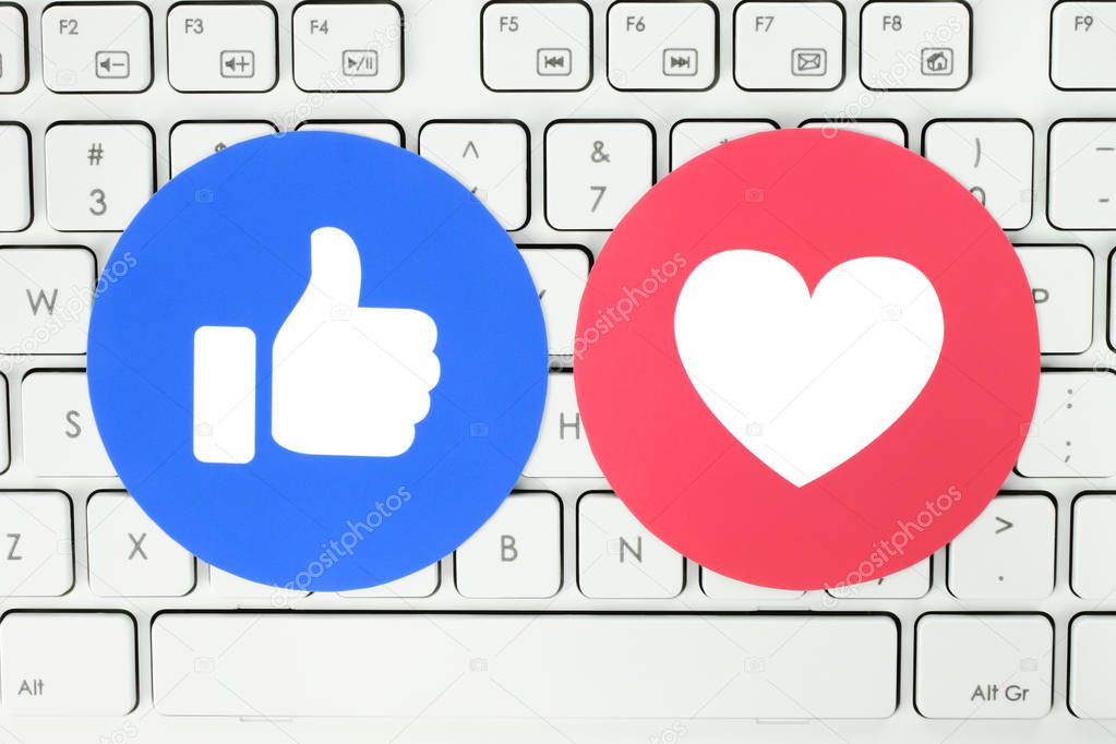 Kiev, Ukraine - November 28, 2018: Facebook Like and Love button of Empathetic Emoji Reactions printed on paper and put on white keyboard