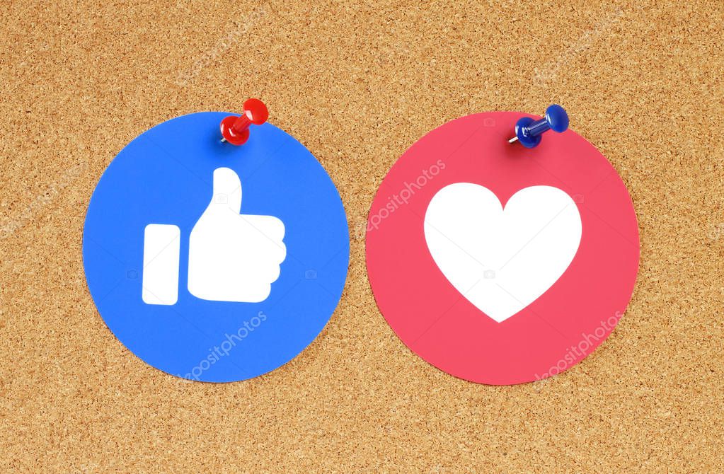 Kiev, Ukraine - November 28, 2018: Facebook Like and Love button of Empathetic Emoji Reactions printed on paper and pinned on cork bulletin board