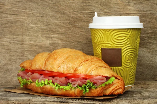 Croissant grande com salada verde, tomates e carne de porco perto de pape — Fotografia de Stock