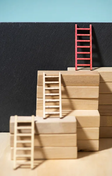 Ladders on the wall. Concept for success and growth. Stairs made of wooden blocks. Blue wall.