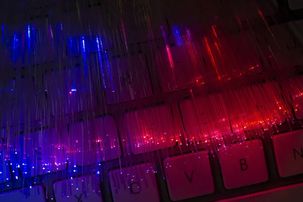 彩色光纤在键盘上照明 高速互联网概念 数据传输光纤电缆 一堆许多光纤 发光不同的颜色 技术背景 — 图库照片