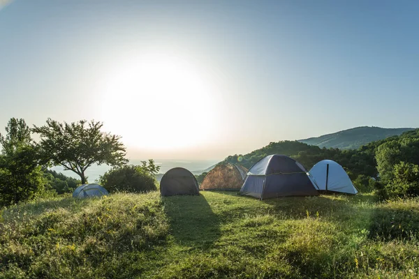 Många tält i berget. Solsken morgon i skogen. — Stockfoto