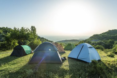 Many tents in the mountain. Sunshine morning in the forest. clipart