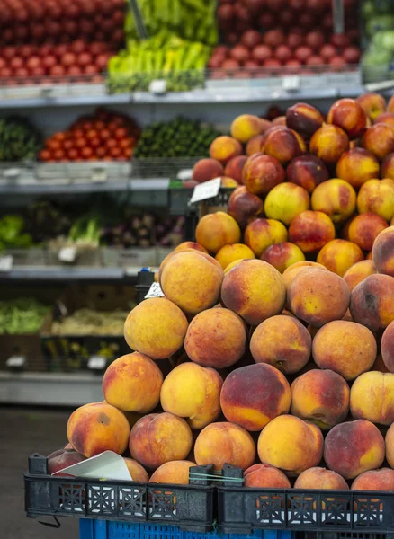 Пачка персиков на рынке. — стоковое фото