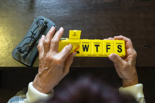 Seniorin nimmt Tabletten aus Schachtel. Gesundheits- und Alterskonzept — Stockfoto