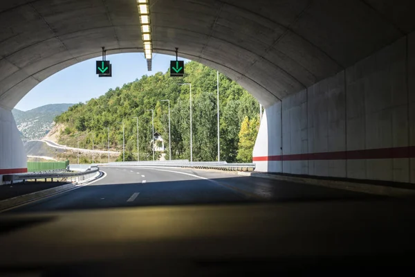 Túnel da estrada. Sinais no túnel. Estrada da montanha. Viagens e traff — Fotografia de Stock