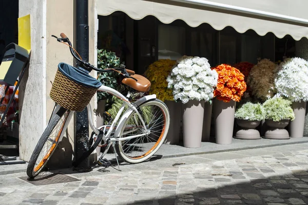 Bicicleta blanca con cesta de mimbre en la calle italiana. Muchas ollas con — Foto de Stock