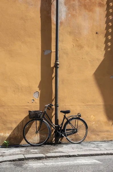 Czarny rower z koszykiem na włoskiej ulicy. Typowy włoski archit — Zdjęcie stockowe