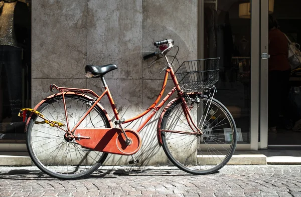 Rotes Fahrrad mit Korb auf der italienischen Straße. typisch italienischer architec — Stockfoto